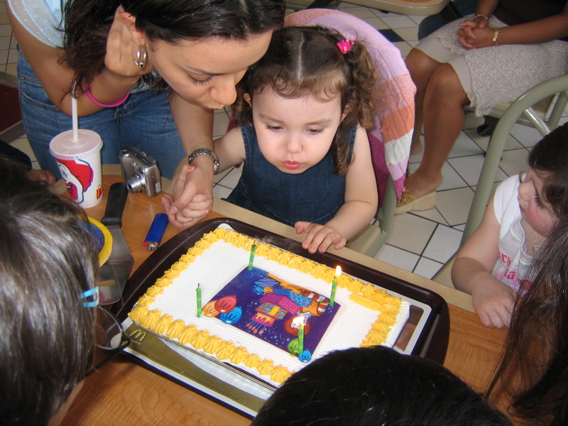 Blowing out her second cake of the day.