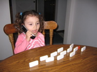 Playing dominos and talking on the phone.