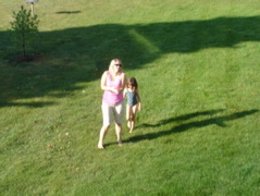 Heather and Novali running in a sprinkler on the way to our pool. 