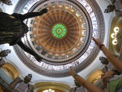 Novali reaching out to the IL Welcoming the World statue under the dome. 