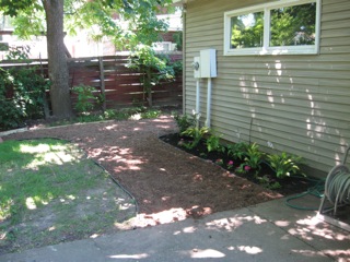 Now has some hostas, flowers and mulch. 